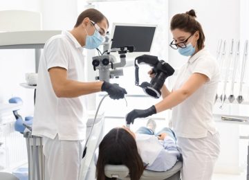 Snapping the result. Skillful dentists taking photo with professional camera of patient teeth